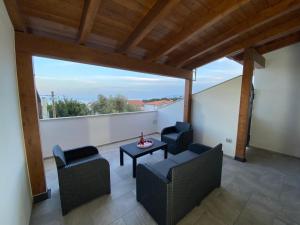 um pátio com 2 cadeiras e uma mesa na varanda em Cala Gonone - Casa del Mirto em Cala Gonone