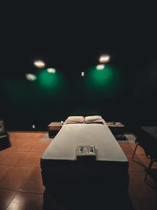 a bed in a room with green lights at Light Motel in Guarulhos