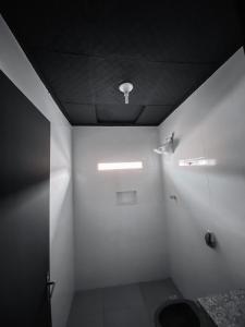 a bathroom with white walls and a black ceiling at Light Motel in Guarulhos