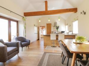 a living room with a table and chairs and a kitchen at Glan Gors in Nantglyn