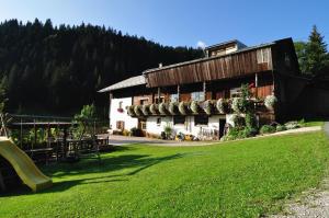 a building with a slide in front of it at Bauernhof Pergila in Maria Luggau