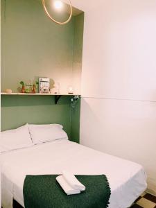 - une chambre avec un lit blanc et un tapis vert dans l'établissement Maria Magdalena - Room 7, à Malaga