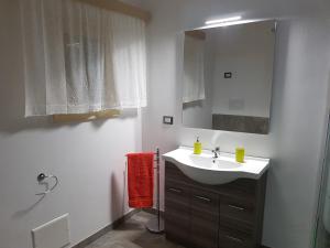 La salle de bains est pourvue d'un lavabo et d'un miroir. dans l'établissement Casa Vacanze Nonna Maria, à Carpignano Salentino