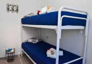 a bedroom with two bunk beds with blue sheets at Casa Nettuno Favignana in Favignana