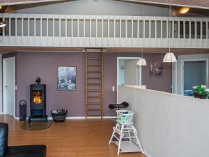 a living room with a staircase and a fireplace at 12 person holiday home in Aabenraa in Loddenhøj
