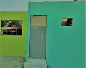 a green building with a blue door and windows at Pousada Vicenzi in Luziânia