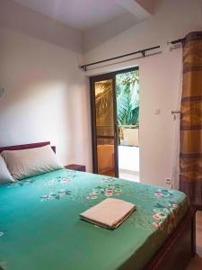 a bedroom with a bed with a towel on it at Appartement F4 Climatisé niveau Etage à Totsi près de la maison ADEBAYOR in Agbalé Pédo