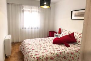 Un dormitorio con una cama con una almohada roja. en Ruby Home, en Santiago de Compostela