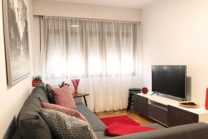 sala de estar con sofá y TV de pantalla plana en Ruby Home, en Santiago de Compostela