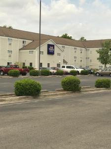 a large building with a parking lot in front of it at InTown Suites Extended Stay Huntsville AL - NASA in Huntsville