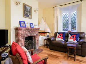 ein Wohnzimmer mit Couch und Kamin in der Unterkunft Aune Cottage in Salcombe