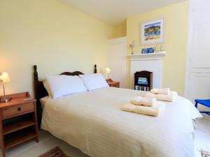 ein Schlafzimmer mit einem großen weißen Bett mit Handtüchern darauf in der Unterkunft Aune Cottage in Salcombe