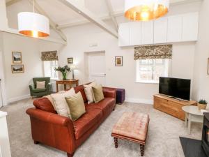 a living room with a couch and a tv at Dairy Cottage in Kirkby Stephen