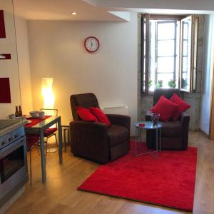 un soggiorno con divano e tappeto rosso di Carmine & Violet Home a Santiago de Compostela