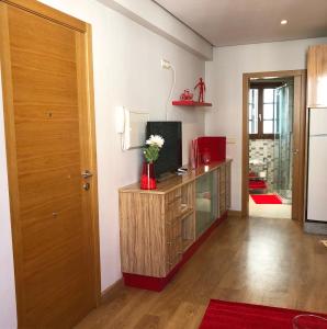 a living room with a television and a wooden door at Carmine & Violet Home in Santiago de Compostela