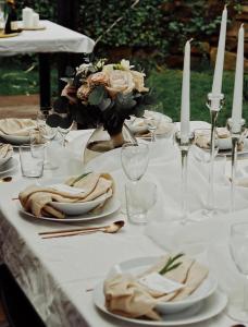 una mesa blanca con platos, velas y flores. en Vila Mia Valtice en Valtice