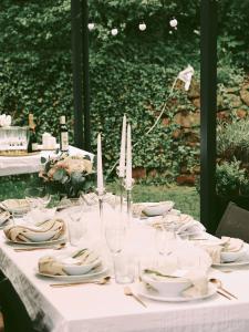 una mesa blanca con platos, vasos y velas en Vila Mia Valtice en Valtice