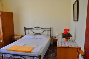 Un dormitorio con una cama y una mesa con flores. en Vai Rent Rooms en Palekastron
