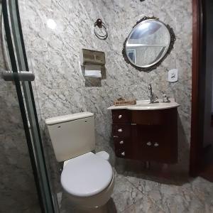 a bathroom with a toilet and a sink and a mirror at SILVÉRIOS Suítes DA MONTANHA in Campos do Jordão
