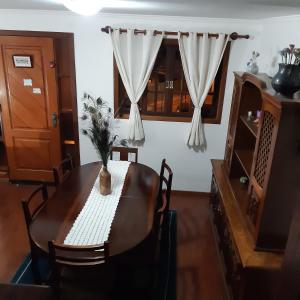 a dining room with a table and a window at SILVÉRIOS Suítes DA MONTANHA in Campos do Jordão +27 photos