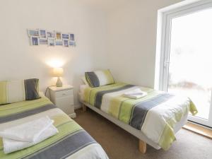 two beds in a room with a window at Clyd Fan in Harlech