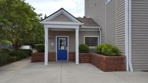 une maison avec une porte bleue et un mur en briques dans l'établissement InTown Suites Extended Stay Knoxville TN, à Knoxville