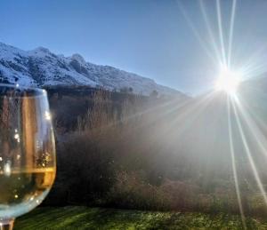 a glass of wine with the sun in the background at Apartamento LLAR DEL CARES in Arenas de Cabrales