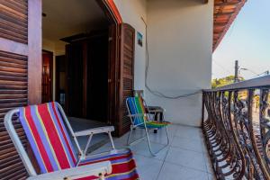 2 chaises et une table sur un balcon dans l'établissement 4 Estações - Arraial, à Arraial do Cabo