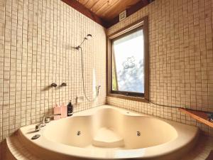 uma grande banheira na casa de banho com uma janela em Kinoie Mornington - OCEANVIEW em Mount Martha
