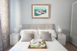 a white bed with a tray of food on it at Primavera Apartments in Sanremo