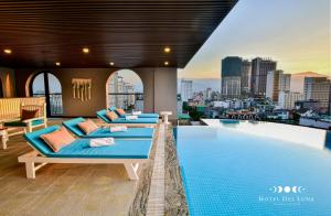 a hotel room with three beds next to a swimming pool at Hotel Del Luna Boutique in Da Nang