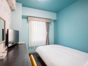 um quarto azul com uma cama e uma televisão em Hotel Wing International Chitose em Chitose