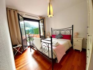 sypialnia z czarnym łóżkiem z czerwonymi poduszkami w obiekcie CASTRO COSTA NORTE Apartamento Jardín Garaje w mieście Castro-Urdiales