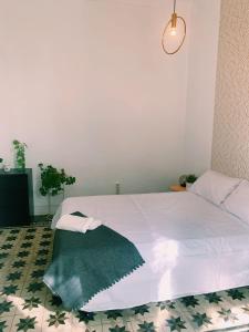 Un dormitorio con una cama con una manta verde. en Maria Magdalena - Room 8, en Málaga