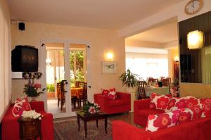 a living room with red couches and a television at Hotel Rita in Riccione