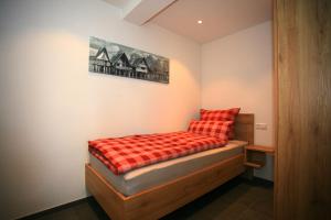 Un pequeño dormitorio con una cama con una manta roja. en Überlinger See-Apartments Apartment 8 Über-See, en Überlingen