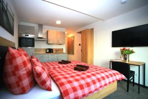 1 dormitorio con cama a cuadros roja y blanca en Überlinger See-Apartments Apartment 5 Über-See, en Überlingen 1 foto más
