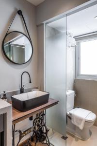 a bathroom with a sink and a toilet and a mirror at Heritage Collection on Seah - Mobile App Check-In in Singapore