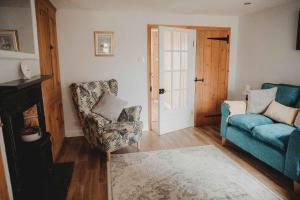 a living room with a blue couch and a chair at Hazel's in Leiston
