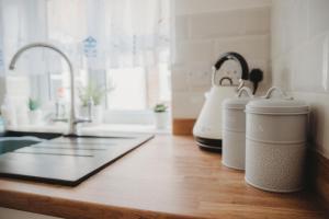 a kitchen counter with a sink and two mugs on it at Hazel's in Leiston +42 photos