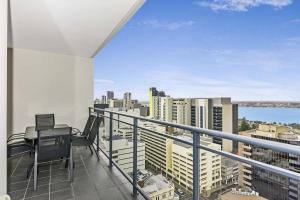 a balcony with a table and chairs and a view of the city at Astra Apartments Perth - Zenith in Perth