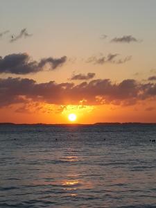 a sunset over the ocean with the sun setting at Casa del Jaguar Beach Hotel in Isla Mujeres