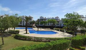 a large swimming pool in front of a building at Apartamento en la Torre Golf Resort in Torre-Pacheco