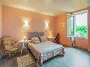 1 dormitorio con paredes de color naranja, 1 cama y ventana en Villa Coste Belle in the heart of nature, en Vers Pont du Gard