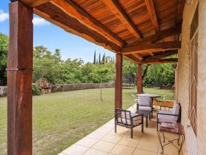 un patio con sillas y una mesa con vistas a un campo en Villa Coste Belle in the heart of nature, en Vers Pont du Gard