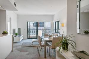 a kitchen and dining room with a table and chairs at Astra Apartments Perth CBD in Perth