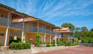 un gran edificio amarillo con balcones. en Higgins Lane Motel en Margaret River