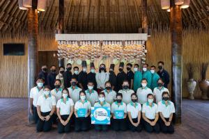 un groupe de personnes posant une photo dans une pièce dans l'établissement Phi Phi CoCo Beach Resort - SHA Extra Plus, sur les Îles Phi Phi