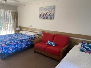 a bed room with two beds and a desk at Shelly Beach Motel in Hervey Bay