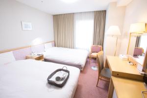 Un pat sau paturi într-o cameră la Toyama Chitetsu Hotel